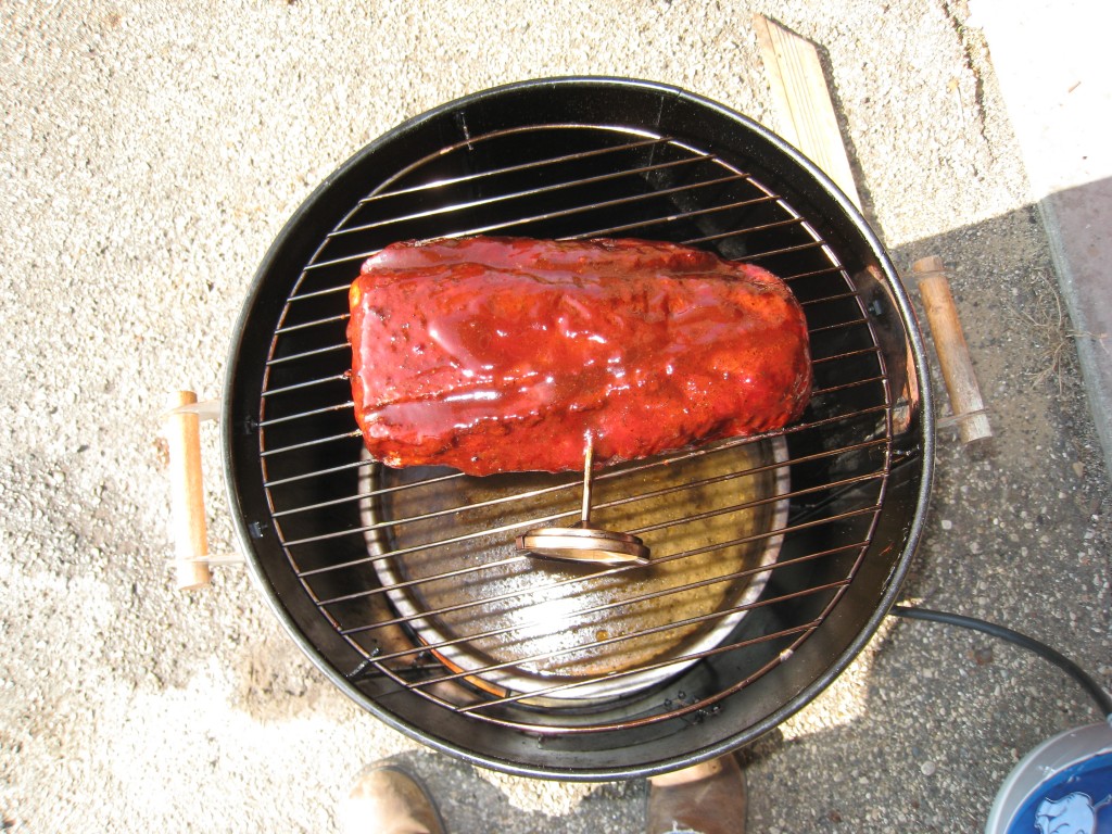 Loin on the smoker covered in BBQ sauce