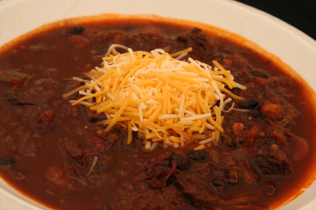 Chili in a bowl stacked with cheese